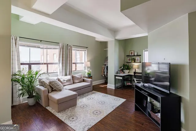 a living room with furniture and a wooden floor