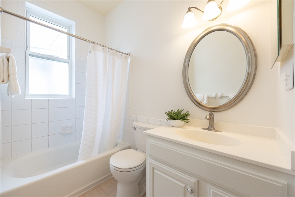 58 Dwight Street, Unit 6 Brookline, MA 02446 - Photo 18 of 21 a bathroom with a sink a toilet and a mirror
