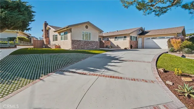 a view of a white house with a small yard and wooden fence