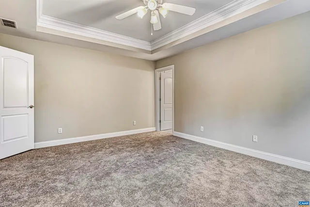 an empty room with windows and chandelier fan