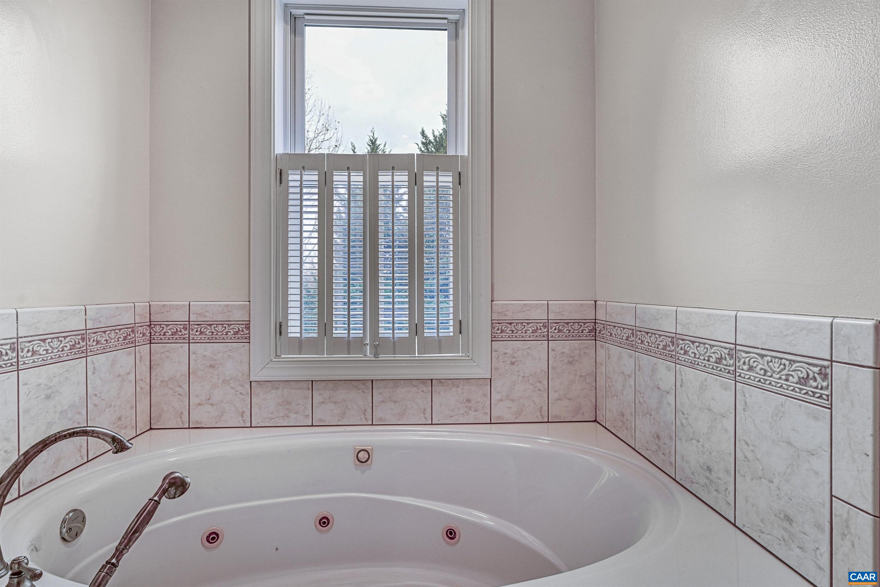 4885 Mechums River Road Charlottesville, VA 22901 - Photo 27 of 72 a bathroom with white bath tub and a window