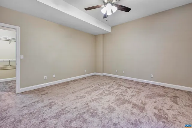 an empty room with windows and ceiling fan