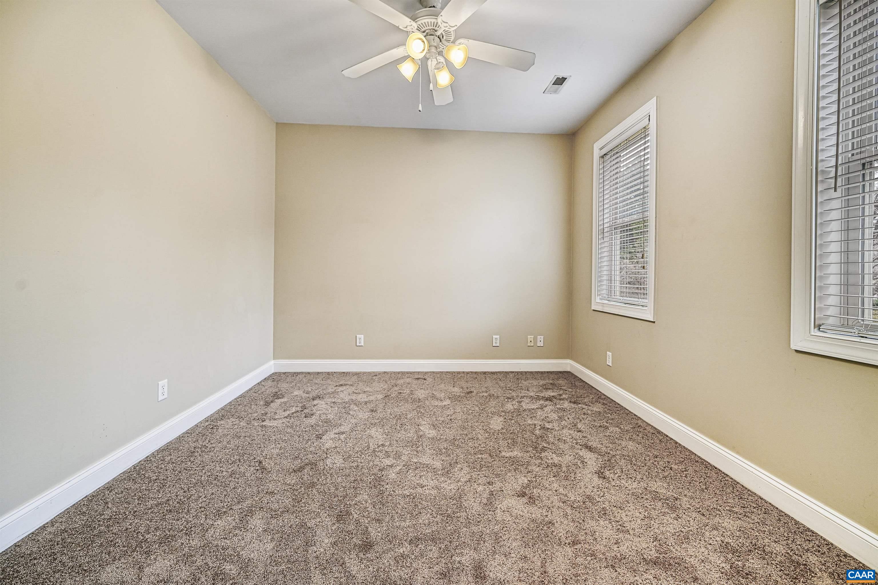 4885 Mechums River Road Charlottesville, VA 22901 - Photo 40 of 72 an empty room with windows and chandelier fan
