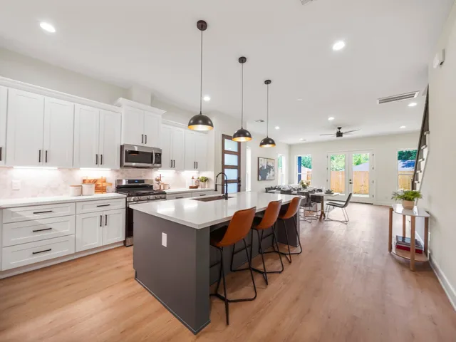 a kitchen with stainless steel appliances kitchen island granite countertop a large island in the center
