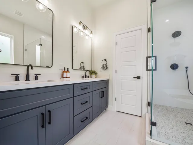 a bathroom with a double vanity sink mirror double and shower