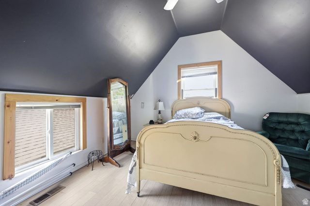 310 South 300 West Payson, UT 84651 - Photo 23 of 42 Bedroom featuring sloped ceilings, two windows with natural wood trim, light wood-finish flooring, and a ceiling fan