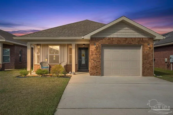 a front view of a house with a yard outdoor seating and garage