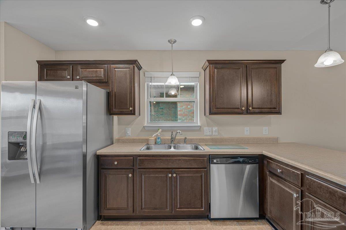 5797 Corkscrew Court Pace, FL 32571 - Photo 11 of 43 a kitchen with stainless steel appliances granite countertop a sink and a refrigerator
