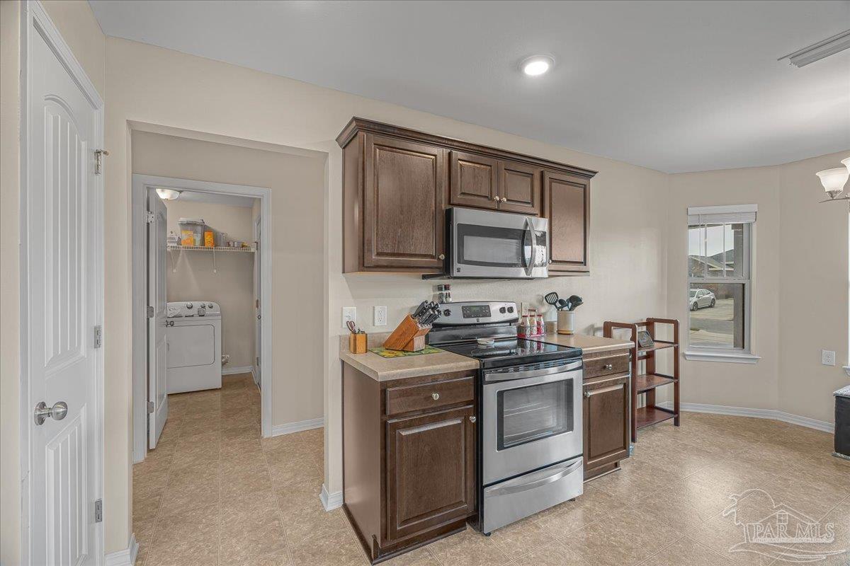 5797 Corkscrew Court Pace, FL 32571 - Photo 13 of 43 a kitchen with stainless steel appliances granite countertop a stove and a sink