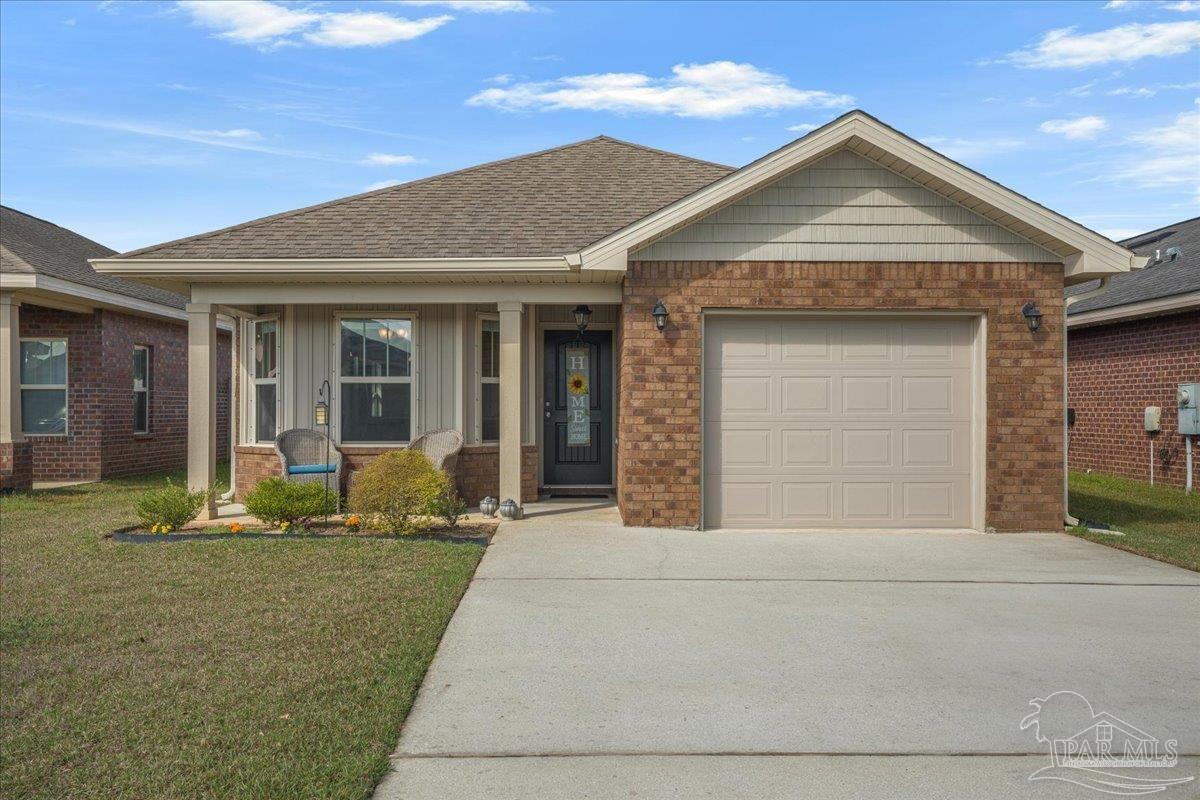 5797 Corkscrew Court Pace, FL 32571 - Photo 2 of 43 a front view of a house with a yard outdoor seating and garage