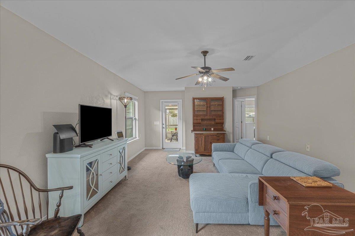 5797 Corkscrew Court Pace, FL 32571 - Photo 22 of 43 a living room with furniture and a flat screen tv