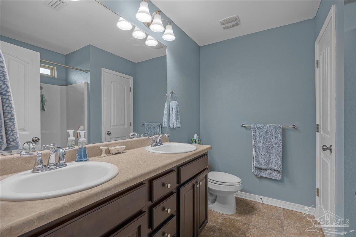5797 Corkscrew Court Pace, FL 32571 - Photo 28 of 43 a bathroom with a double vanity sink toilet and a mirror