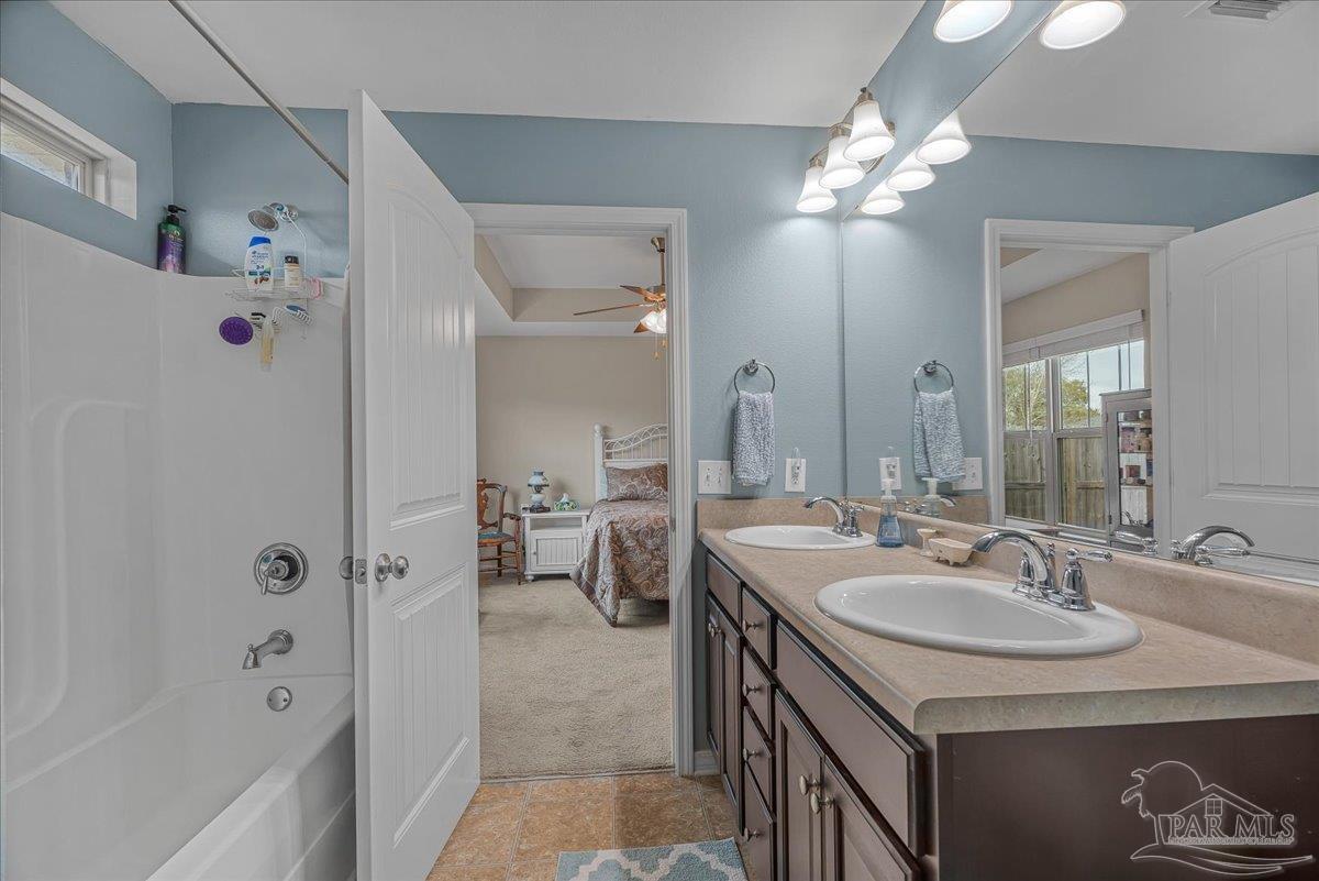 5797 Corkscrew Court Pace, FL 32571 - Photo 29 of 43 a spacious bathroom with a sink double vanity granite tub shower and a mirror