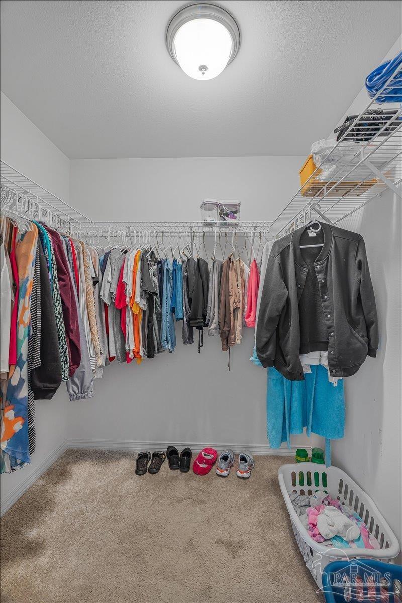 5797 Corkscrew Court Pace, FL 32571 - Photo 30 of 43 a view of walk in closet with clothes and shoes
