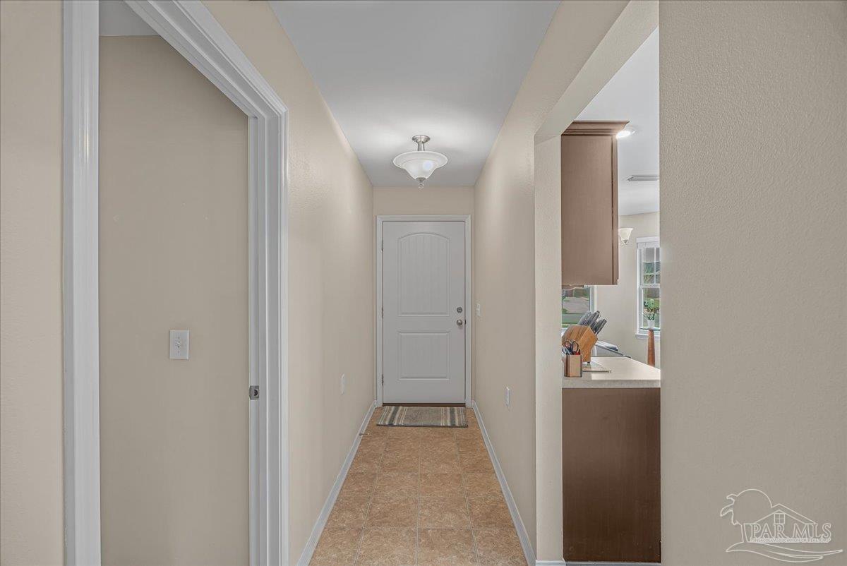 5797 Corkscrew Court Pace, FL 32571 - Photo 10 of 43 a view of a hallway with wooden floor and a bathroom