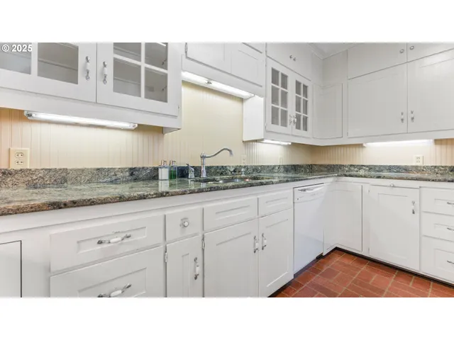 a kitchen with granite countertop white cabinets and stainless steel appliances
