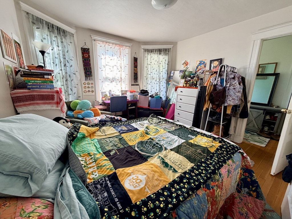 91 Academy Hill Road, Unit 91 Boston, MA 02135 - Photo 2 of 15 a bed room with furniture and a flat screen tv