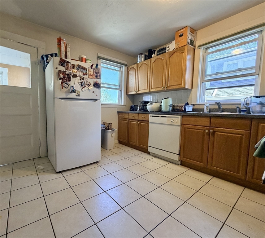 91 Academy Hill Road, Unit 91 Boston, MA 02135 - Photo 10 of 15 a kitchen with stainless steel appliances granite countertop a refrigerator sink and cabinets