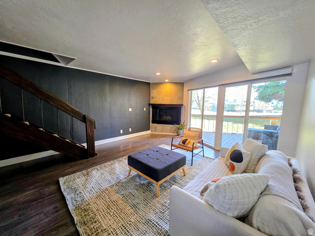 5265 South Rome Beauty Park Murray, UT 84123 - Photo 14 of 35 Living room featuring dark wood finished floors, a fireplace, a textured ceiling, recessed lighting, and wood walls