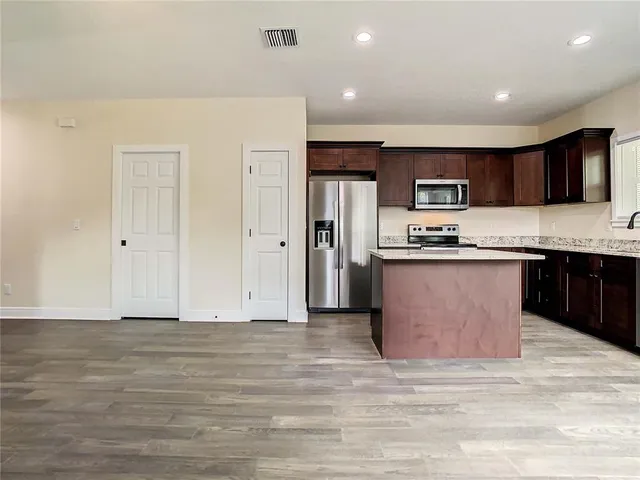 a kitchen with stainless steel appliances granite countertop a stove a sink and a microwave