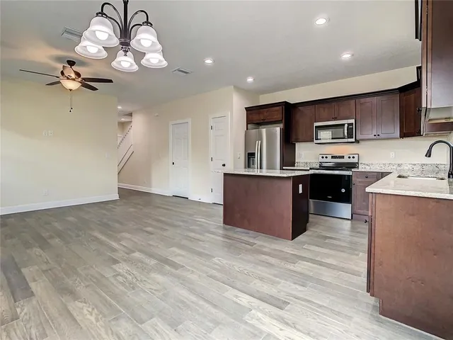 a kitchen with stainless steel appliances granite countertop a refrigerator and a stove top oven