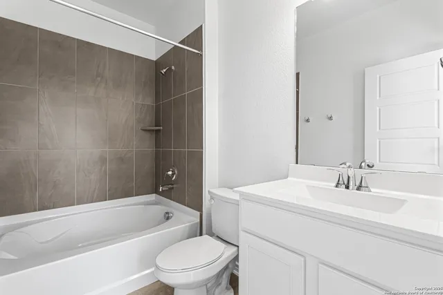a bathroom with a bathtub shower sink vanity and toilet