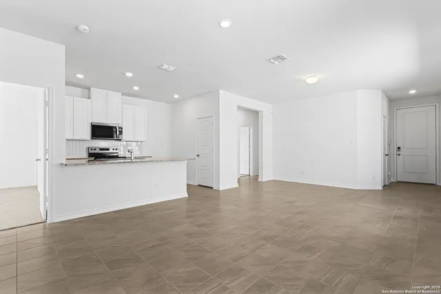a view of kitchen with stainless steel appliances a refrigerator and a stove top oven