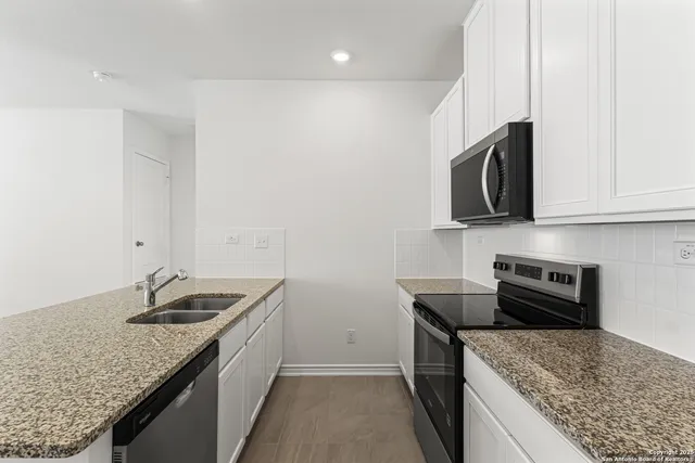 a kitchen with stainless steel appliances granite countertop a sink stove and microwave