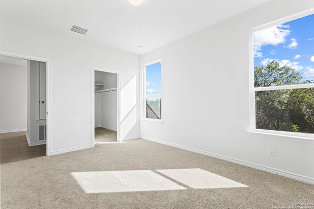 an empty room with large window and doors
