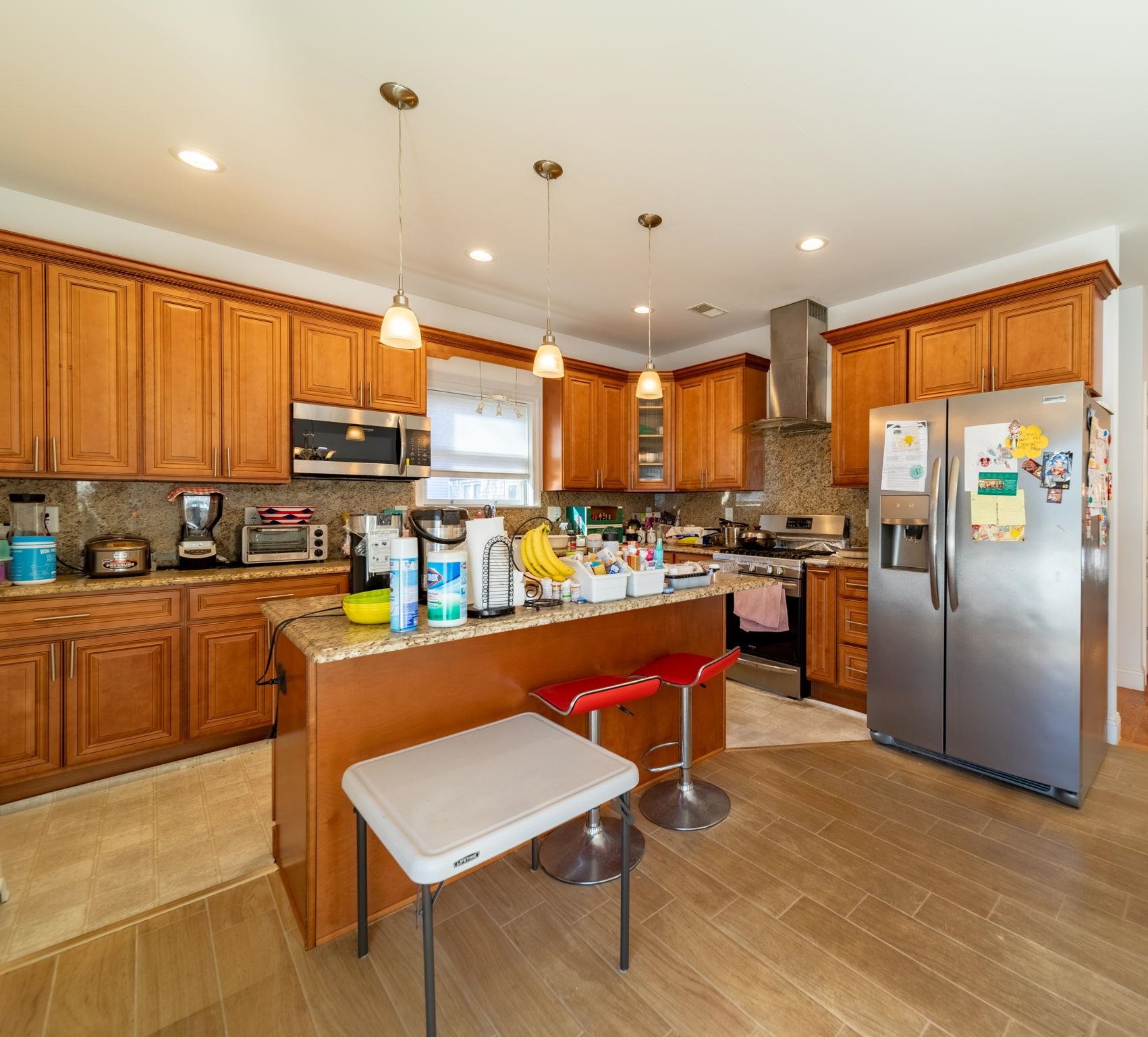 826 Eighth Street Secaucus, NJ 07094 - Photo 9 of 12 a kitchen with stainless steel appliances granite countertop a refrigerator a stove top oven a sink a dining table and chairs