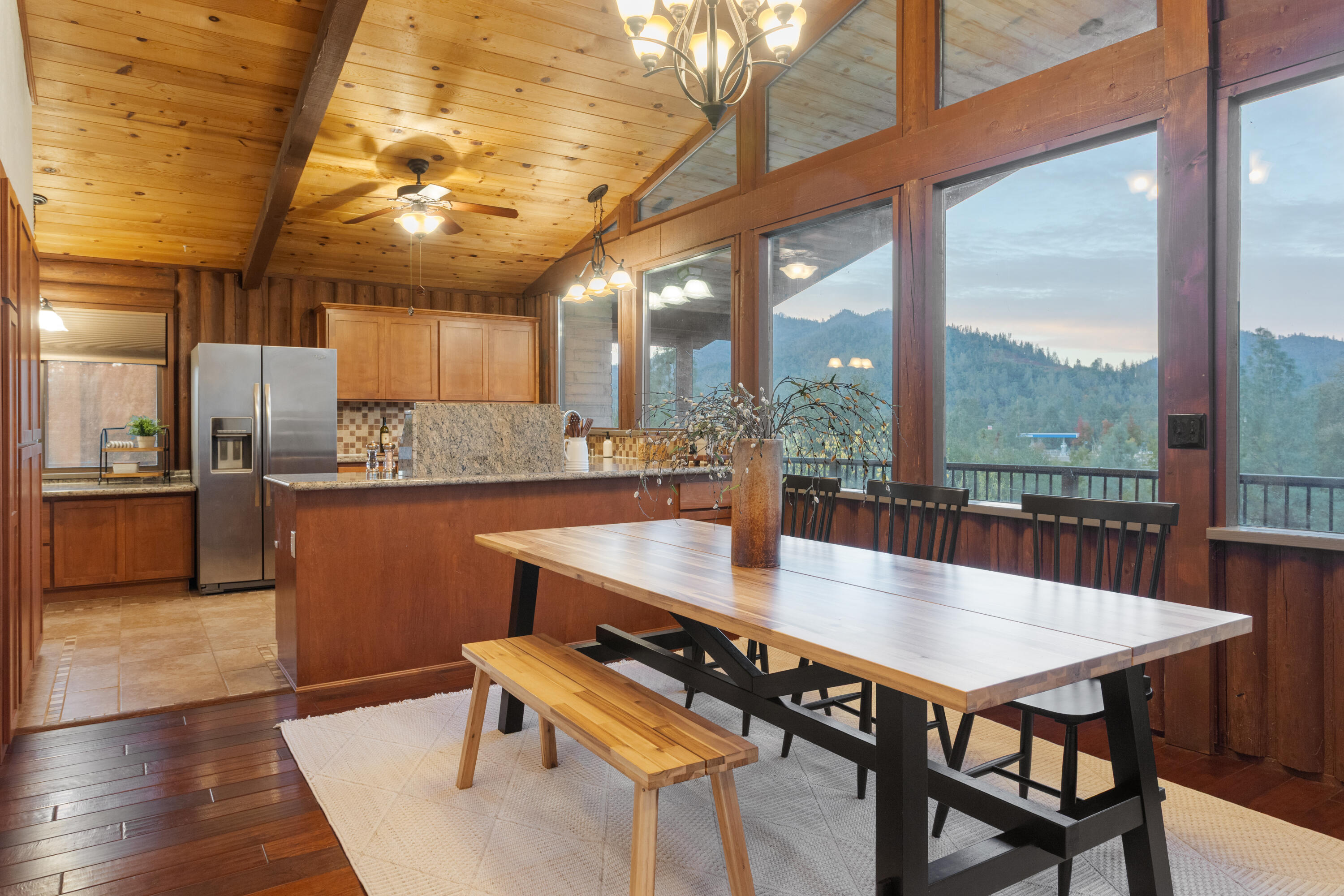 19606 Fish Hill Lane Redding, CA 96003 - Photo 9 of 24 a dining room with stainless steel appliances granite countertop a table chairs and a ocean view