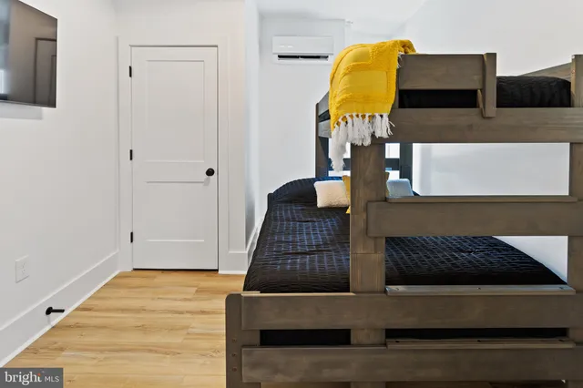 a bedroom with a bed and teddy bear on bed
