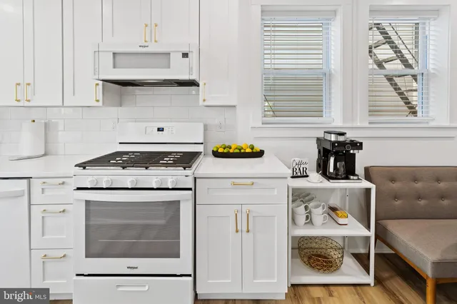 a kitchen with white cabinets and white appliances