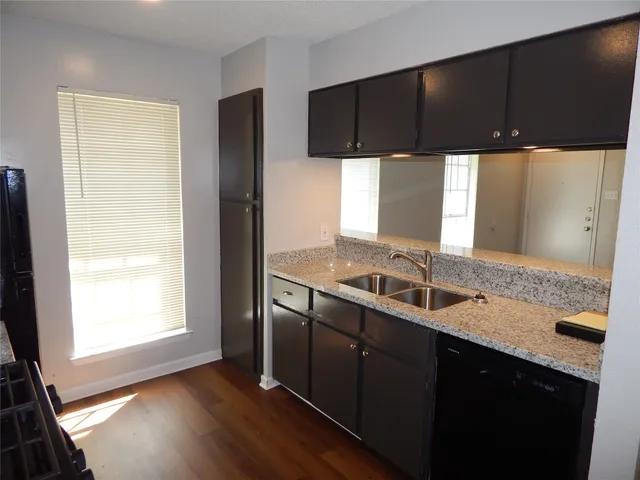 a kitchen with a sink a window and cabinets