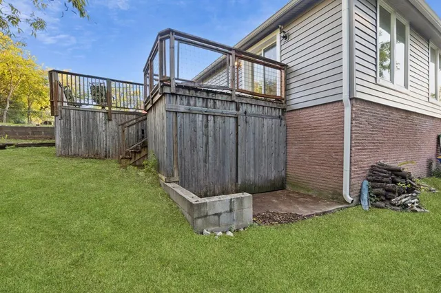a view of a backyard with barbeque grill and wooden fence