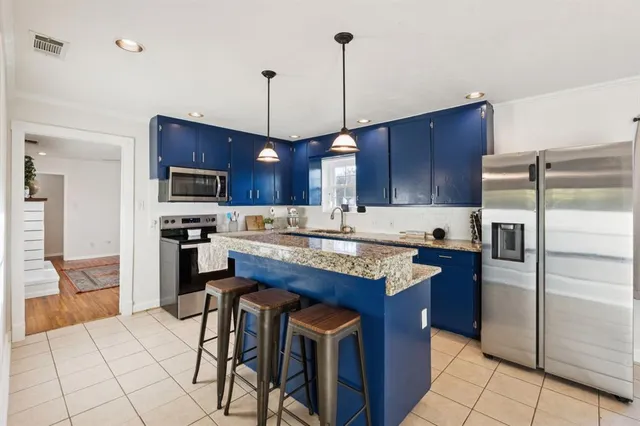 a kitchen with stainless steel appliances granite countertop a stove top oven a refrigerator a sink and dishwasher