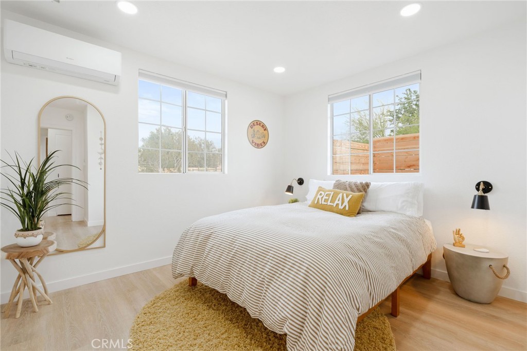 62046 Mountain View Circle Joshua Tree, CA 92252 - Photo 16 of 69 a bedroom with a bed and windows