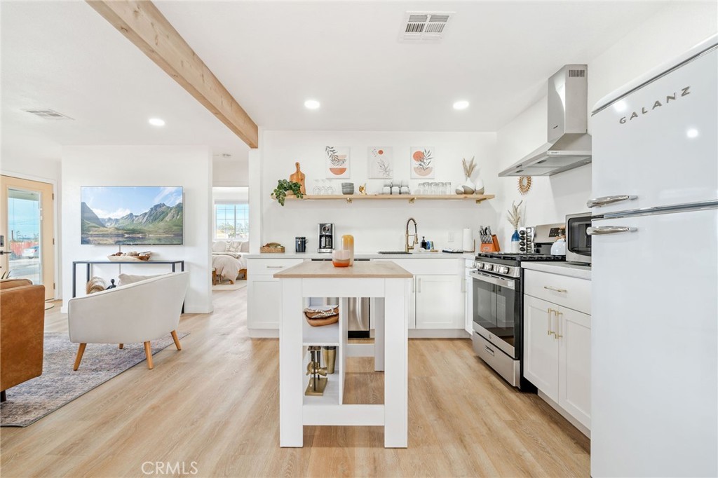 62046 Mountain View Circle Joshua Tree, CA 92252 - Photo 8 of 69 a kitchen with white cabinets and stainless steel appliances