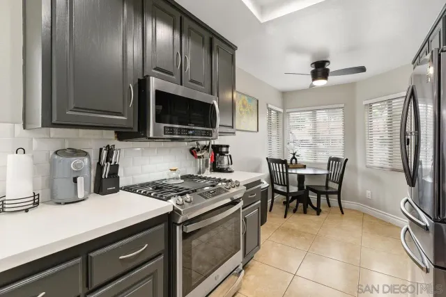 a kitchen with granite countertop a stove a sink a dining table and chairs