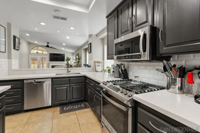 a kitchen with kitchen island granite countertop a sink stainless steel appliances and cabinets