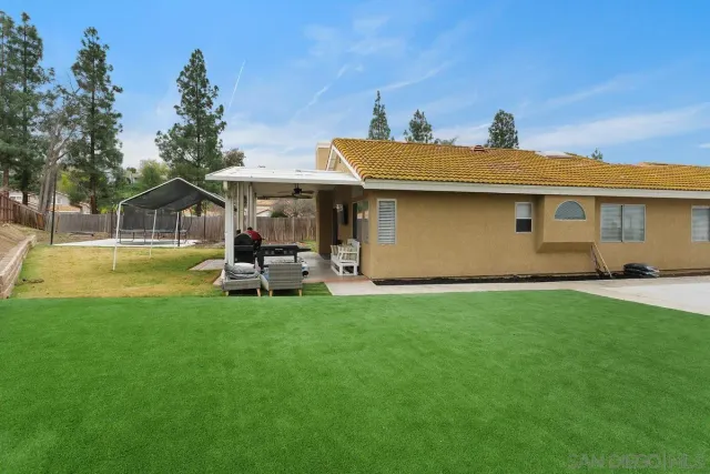 a view of a patio with table and chairs under an umbrella