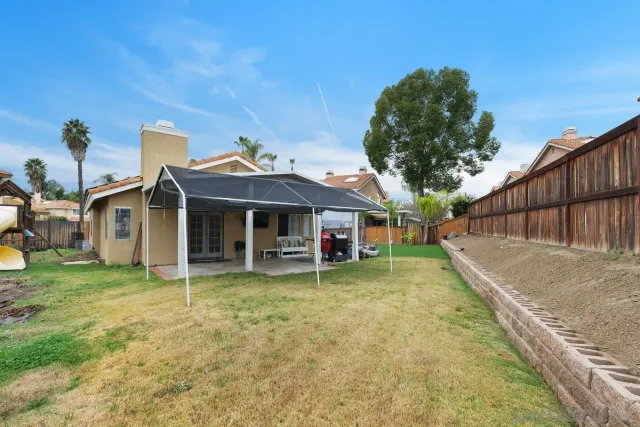 a view of a house with a yard and sitting area