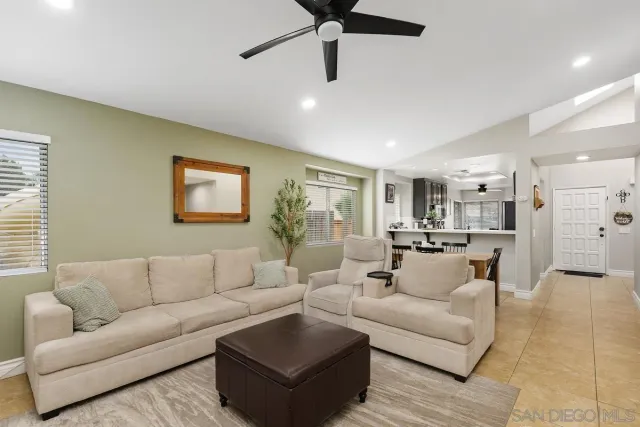 a living room with furniture and a view of kitchen