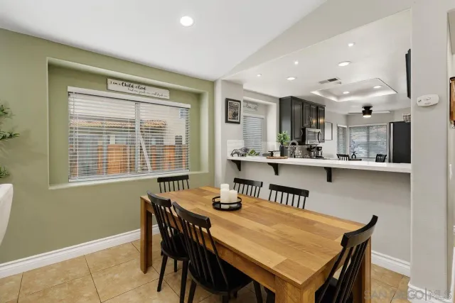 a dining room with a table chairs and a kitchen view