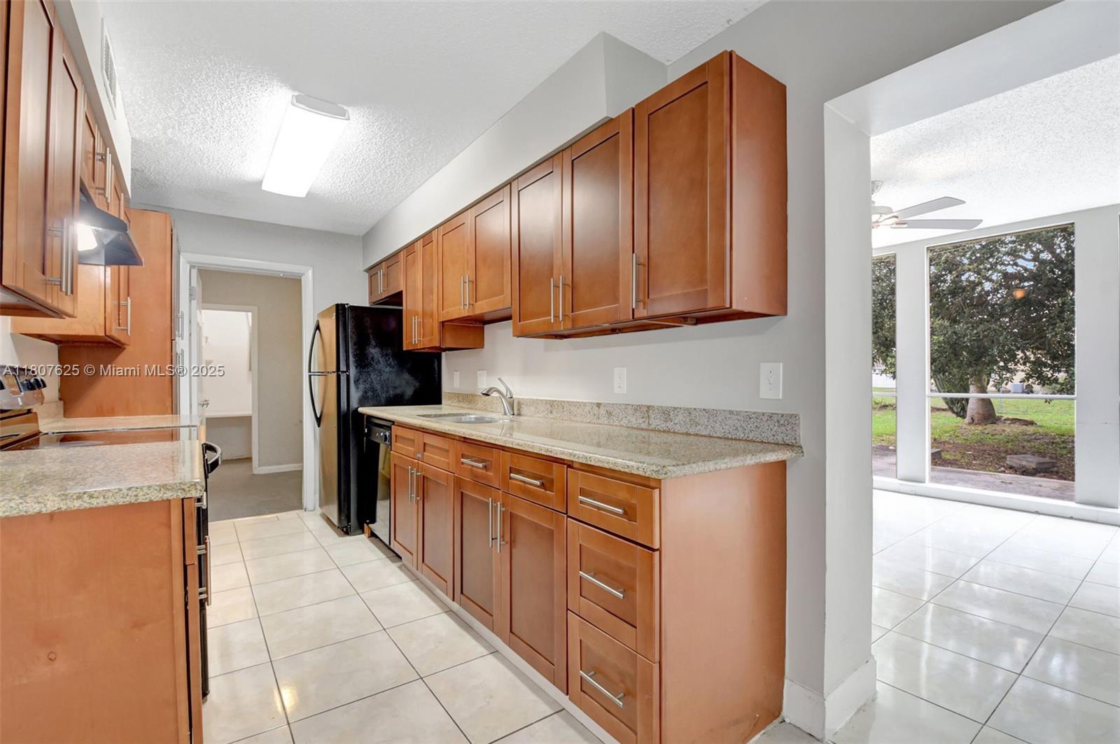 6160 Camp Lee Road West Palm Beach, FL 33417 - Photo 11 of 42 a kitchen with stainless steel appliances granite countertop wooden cabinets a sink and a stove