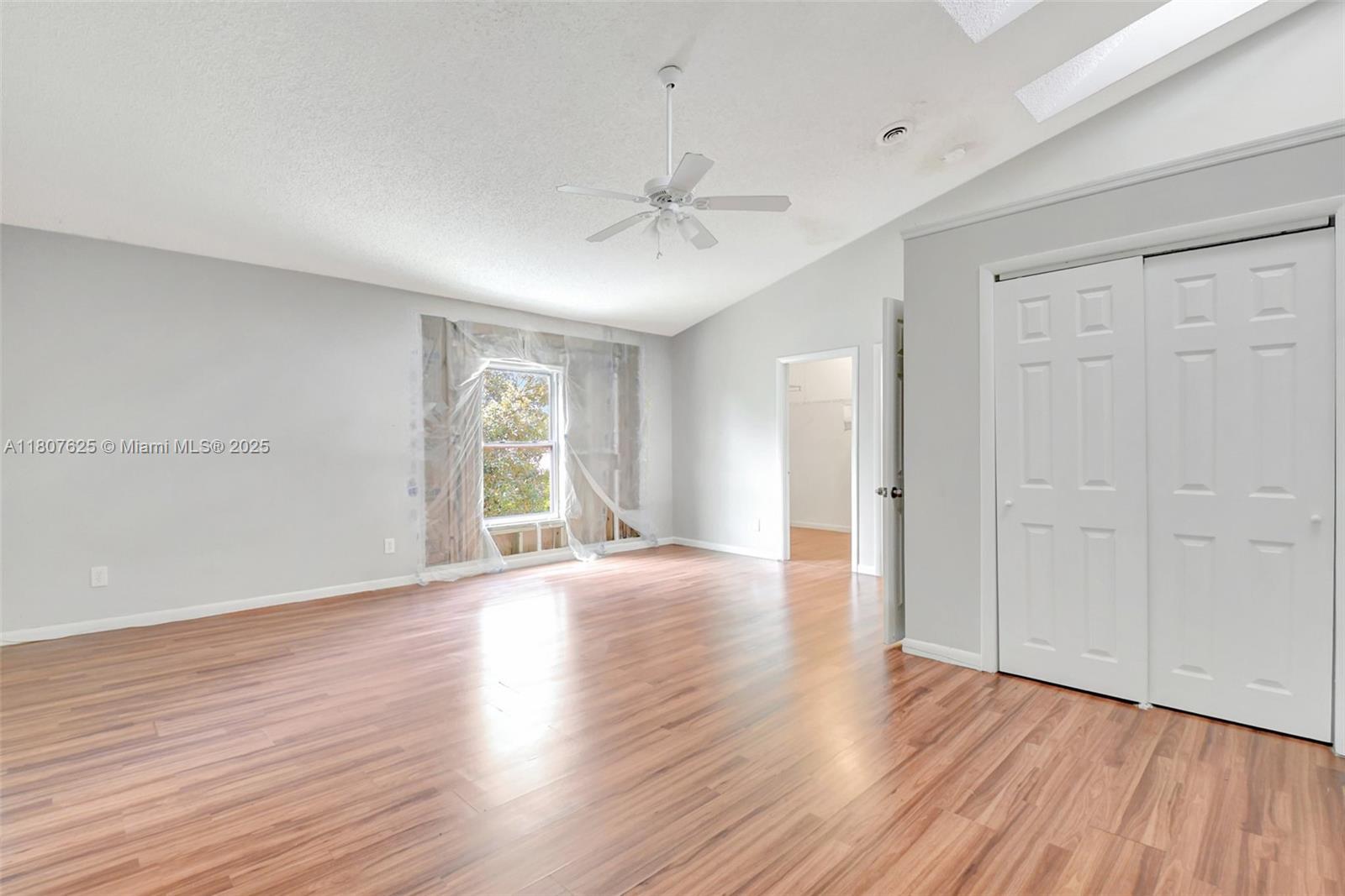 6160 Camp Lee Road West Palm Beach, FL 33417 - Photo 31 of 42 an empty room with wooden floor chandelier fan and windows