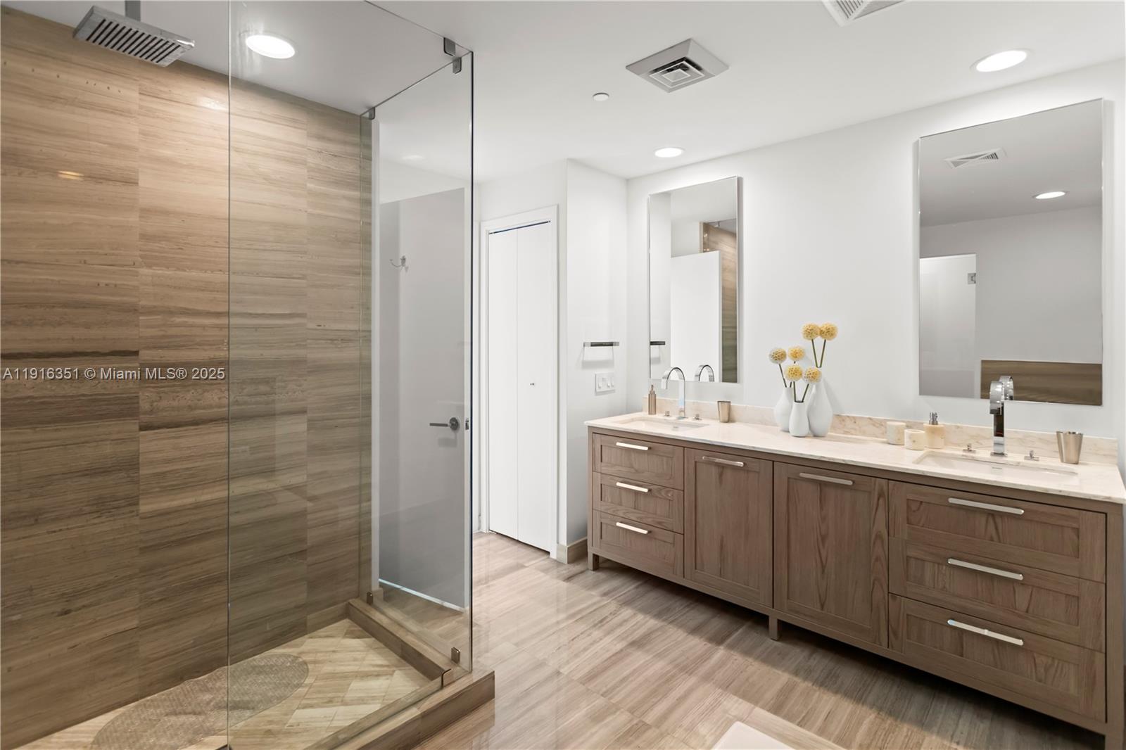 350 Ocean Drive, Unit 904N Key Biscayne, FL 33149 - Photo 19 of 40 a spacious bathroom with a double vanity sink a large mirror and shower