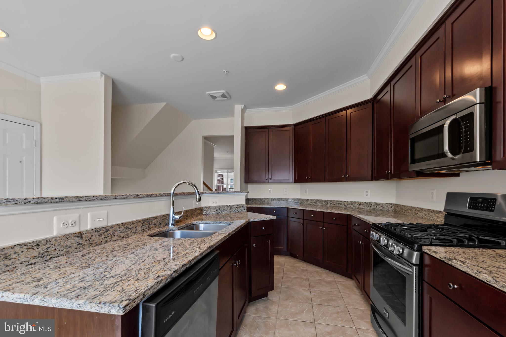 830 Ryan Street Baltimore, MD 21230 - Photo 10 of 24 a kitchen with granite countertop stainless steel appliances a sink a stove cabinets and a kitchen island