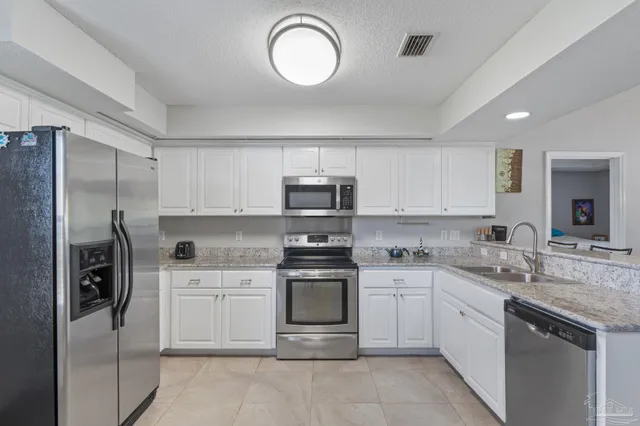 a kitchen with a sink stainless steel appliances and cabinets