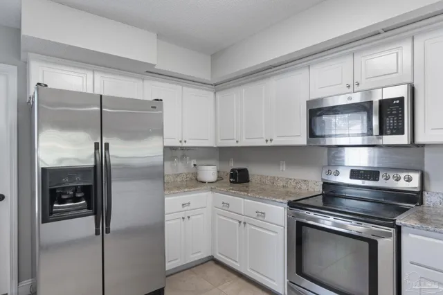 a kitchen with cabinets stainless steel appliances and a counter space